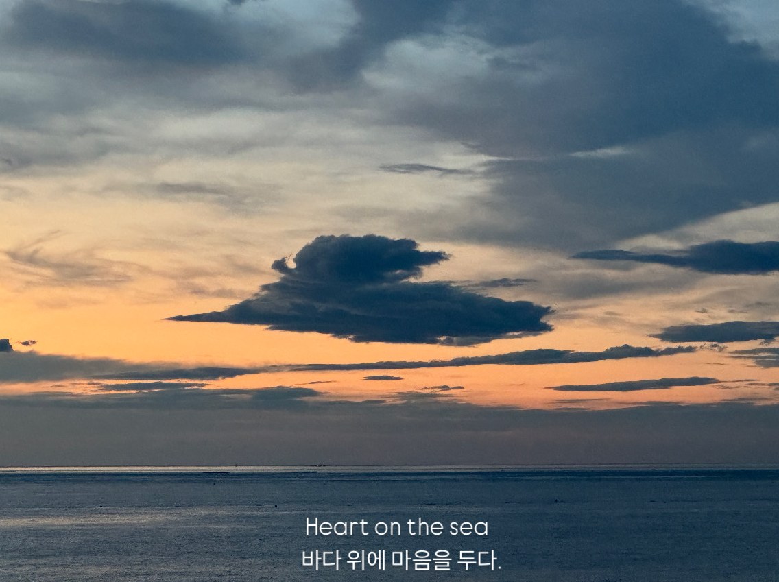 노을 진 남애 바다 사진 위에 'Heart on the sea, 바다 위에 마음을 두다.'라고 쓴 구피스탠스 엽서
